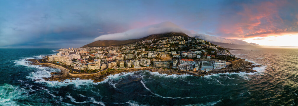 Panoramic aerial view of Bantry Bay and low cloud over Lion&rsquo;s Head Mountain with Table Mountain in background at sunset, Bantry Bay, Cape Town, South Africa.