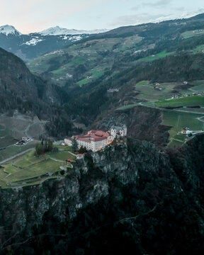 Aerial view of Sabiona Monastery and Chiusa town with terraced fields, Klausen, South Tyrol, Italy.