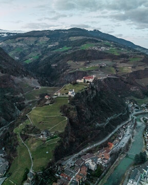 Aerial view of Sabiona Monastery and Chiusa town with Dolomites in sunset, Klausen, South Tyrol, Italy.