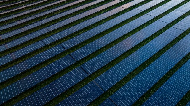 Aerial Drone view of reflective solar panels during sunset, green energy farm, The Netherlands.