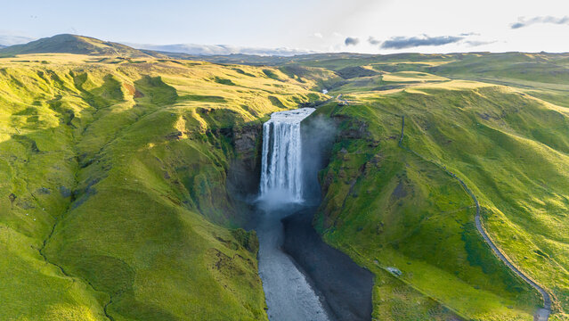 Aerial drone view of Skógafoss waterfall during sunrise in summer time, Southern Iceland.