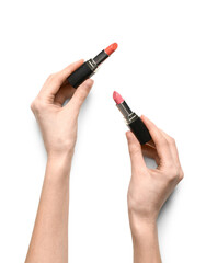 Female hands with color lipsticks on white background