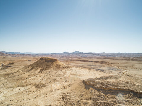 Aerial view of dry desert landscape with high dunes and rocky formations, Southern District, Israel.