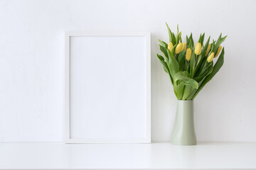 Bunch of yellow tulips and empty frame mockup.