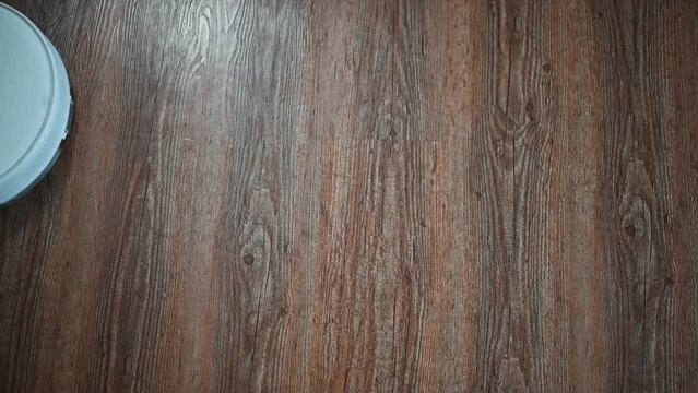 Top view robot vacuum cleaner cleaning parquet floor indoors