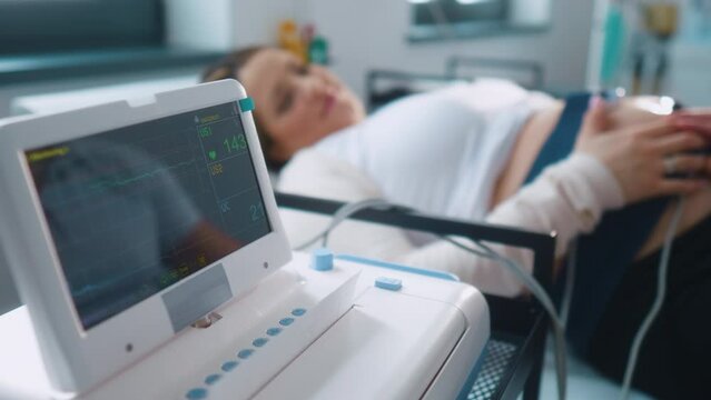 Cardiotocograph machine monitor baby heartbeat in hospital clinic pregnant woman