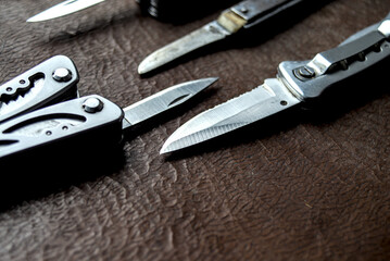 Folding knives on brown background.