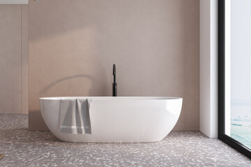A white bathtub with a towel draped over the side. The bathroom is clean and well-lit