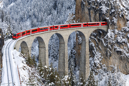 Rhaetian Railway passenger train at the famous Landwasser Viaduct on Albula line by Stadler Rail in the Swiss Alps in Filisur, Switzerland