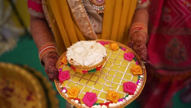 Closeup of Indian women holding a Haldi Paste or Turmeric Paste in Hand for Haldi Ceremony, Traditional Indian Hindu Weddings Background