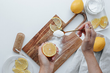 wooden cutting board with soda and lemons on a white background. a woman's hand with a lemon and a...