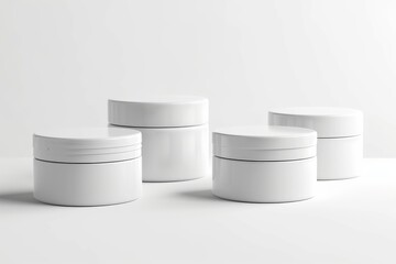 Four silver rectangular jars are elegantly arranged in a monochrome still life composition on a white surface, showcasing a minimalist and sophisticated fashion accessory display