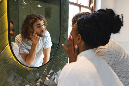 A diverse couple is in the bathroom doing their morning skincare routine - Powered by Adobe