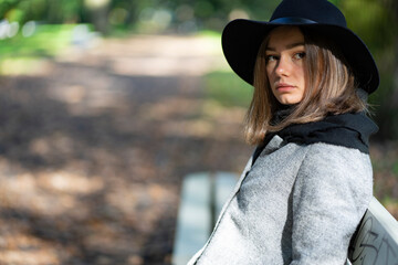Portrait of a young girl sitting on a park bench