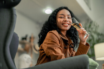 Young Black Female Designer Relaxes With a Glass of Wine Post-Work in Cozy Studio
