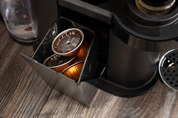 Open container for used coffee capsules in a coffee machine. Selective focus.