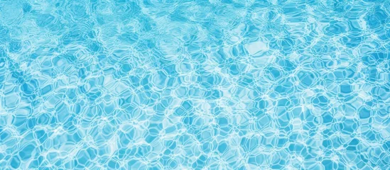 Poster Close up of the liquid azure water in a swimming pool, creating an electric blue pattern that shimmers like a fluid organism in an aqua font © 2rogan
