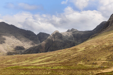 The rugged grandeur of the Cuillin Hills looms over the Fairy Pools, offering a majestic view against the stark beauty of Isle of Skye famous landscapes