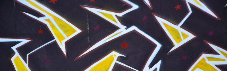 Colorful background of graffiti painting artwork with bright aerosol outlines on wall. Old school...