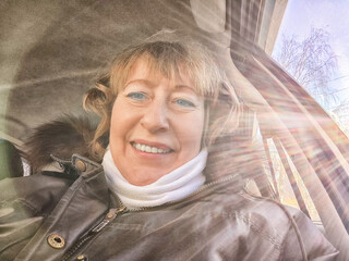 Woman in a Car Taking a Selfie and and the rays of the sun in the background