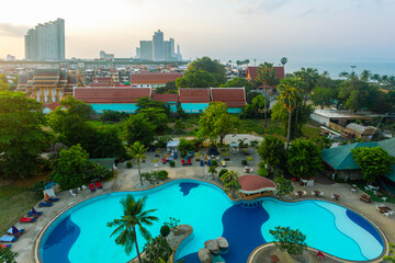  Top view of swimming pool, hotels, palms near coast beach in Pattaya city, Thailand.