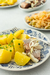 Delicious hearty fish dinners, boiled potatoes with pickled herring, sauerkraut with onions and olive oil