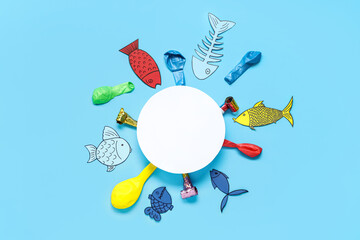 Blank card with paper fishes, balloons and party whistles on blue background. April Fools Day...