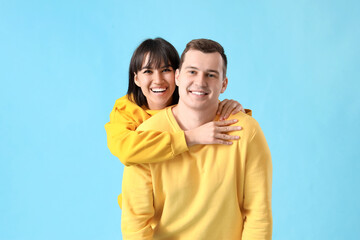 Young couple in love hugging on blue background