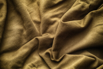 A crumpled beige fabric texture background. Close up.