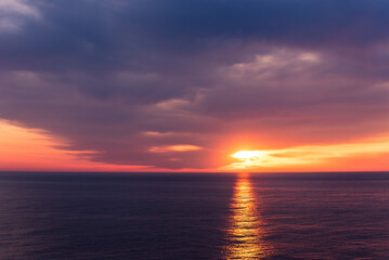 Naklejka na ściany i meble Beautiful sunset sky over the calm ocean.