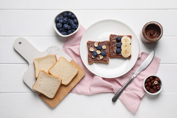 Naklejka premium Different tasty toasts with nut butter and products on white wooden table, flat lay