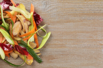 Peels of fresh vegetables on wooden table, top view. Space for text