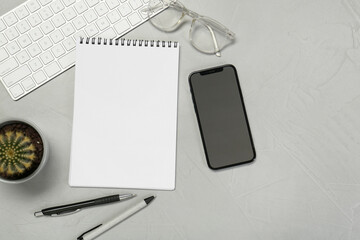 Flat lay composition with open notebook and smartphone on light grey table