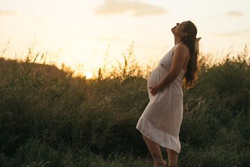 Mujer embarazada contemplando el atardecer