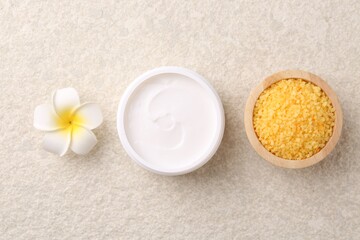 Fototapeta na wymiar Body care. Moisturizing cream, sea salt and flower on light textured table, flat lay