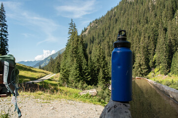  Reusable Blue Water Bottle on Rustic Wooden Surface with Alpine Background - 763332049