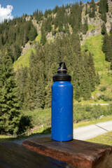  Reusable Blue Water Bottle on Rustic Wooden Surface with Alpine Background - 763332205