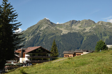 Alpine Village with Mountain Backdrop in Summer - 763332252