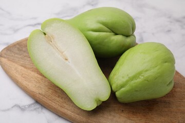 Fresh green chayote on light marble table, closeup