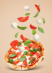 Caprese pizza and ingredients in air on dark beige background