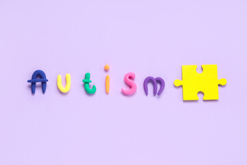 Word AUTISM made from plasticine with puzzle on lilac background