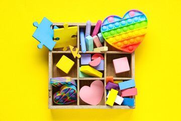 Colorful toys and pop it on yellow background. Concept of autistic disorder