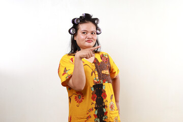 Asian housewife standing while pointing something sideways