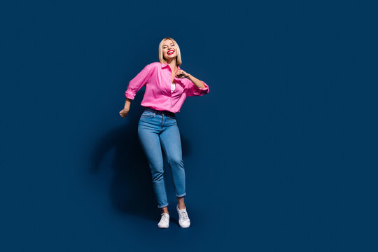 Full size photo of gorgeous pleasant cute girl dressed pink shirt jeans dancing in night club isolated on dark blue color background