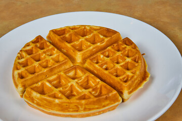 Golden Brown Waffle Quarters on White Plate, Eye-Level View