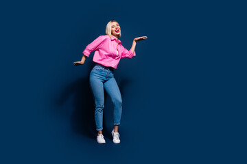 Full size photo of cheerful adorable nice girl dressed pink shirt jeans dancing at disco party isolated on dark blue color background