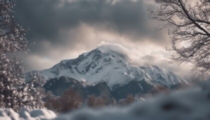 Fototapeta premium Mountain covered in snow under a cloudy sky