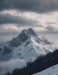 Fototapeta premium Mountain covered in snow under a cloudy sky