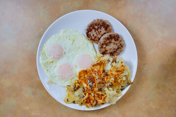 American Breakfast Plate with 3 Sunny Side Eggs, Sausage, Hash Browns - Top View