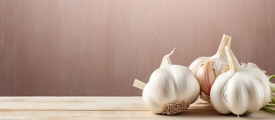 Three garlic bulbs on a wooden table with a brown background